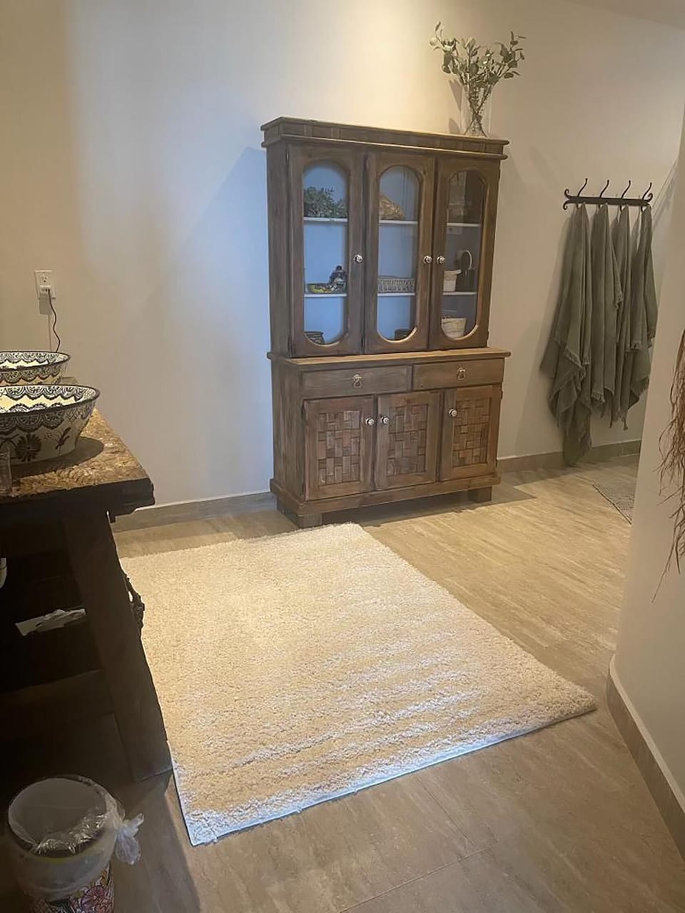 Cozy entryway to master bathroom with rustic wooden cabinet and warm lighting