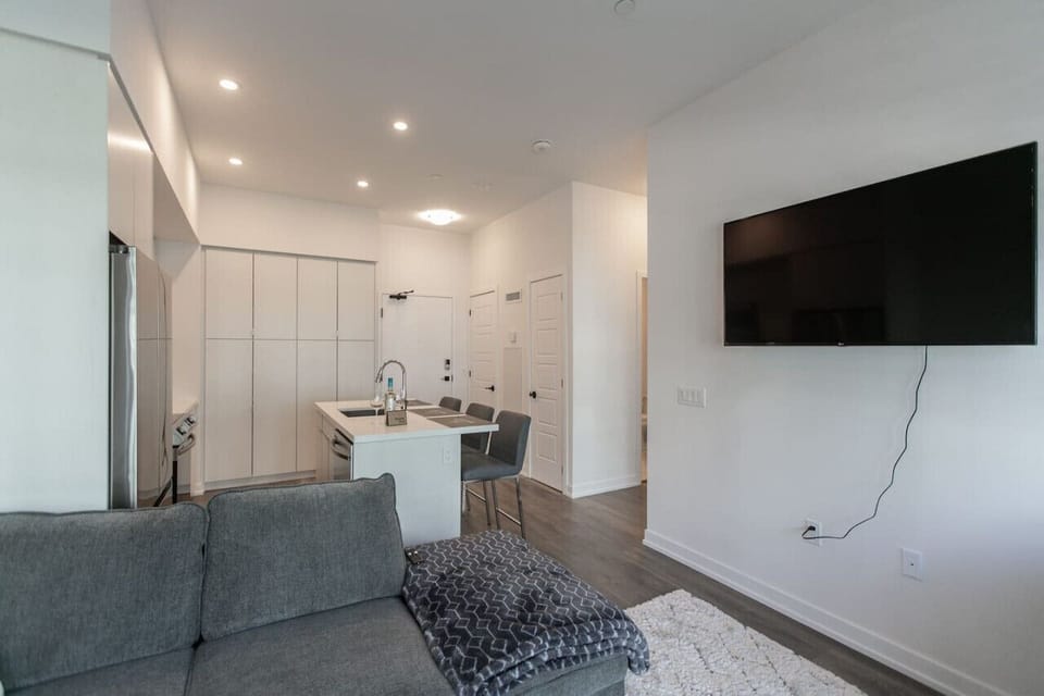 Living room is furnished with a pull-out couch and a Smart TV.