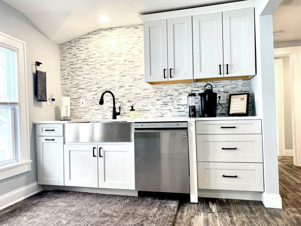 Keurig station with Starbucks coffee, stocked dishes, dishwasher for easy cleanup, and supplies belo