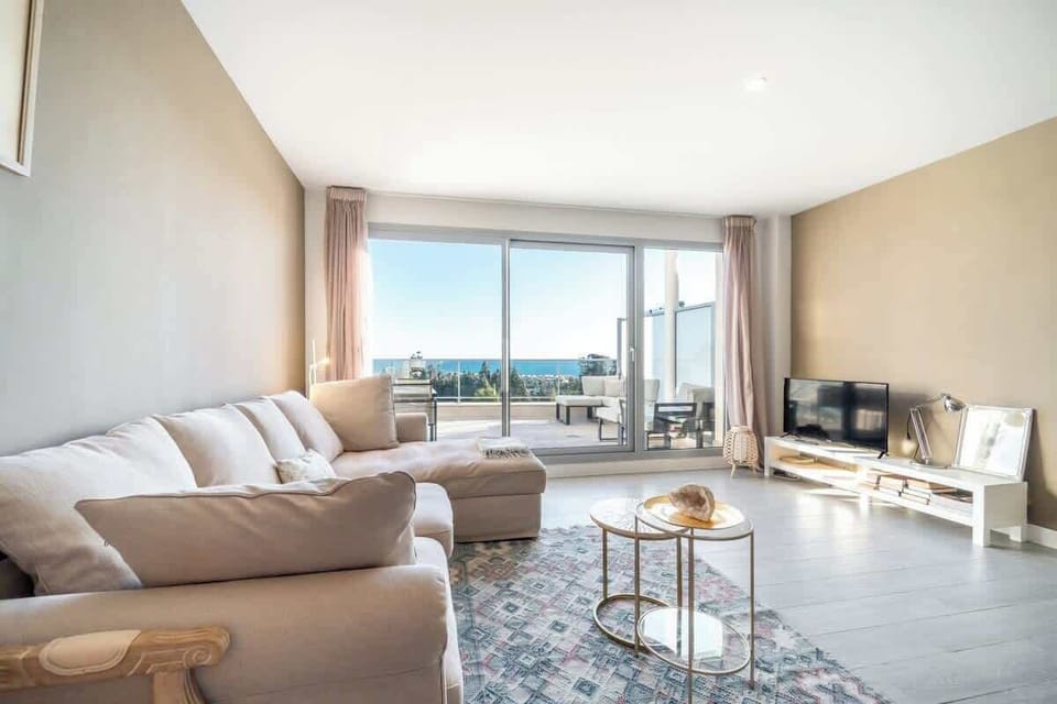 Spacious open living area with comfy sofa, kitchen, and dining for guests to enjoy.