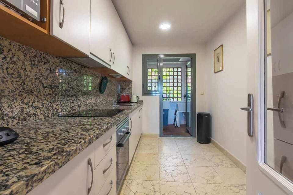 Fully furnished kitchen leading onto a laundry area. Kitchen equipped with oven, hob fridge freezer, washing machine, kettle, toaster, microwave, coffe maker.