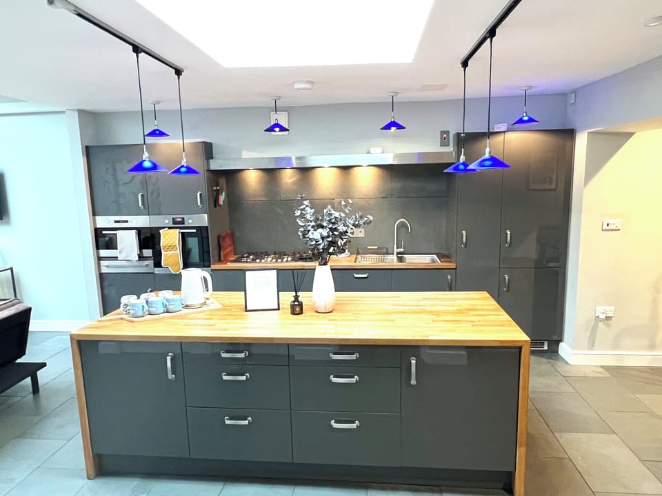 Kitchen: Sleek design meets vibrant blue lights—your culinary creativity awaits!