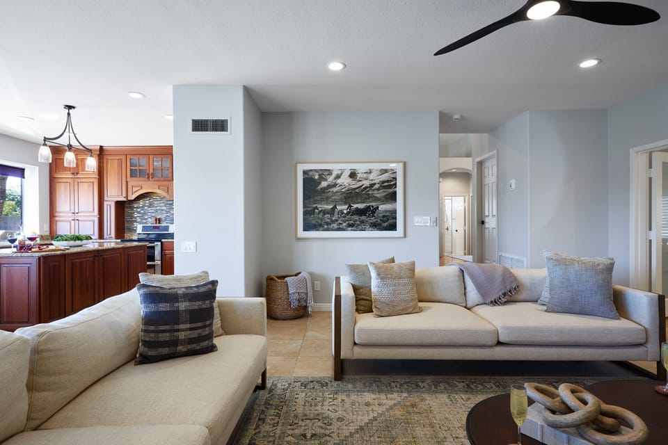 Bright open floor living space featuring a smart flat-screen TV, designer furnishings, and access to the outdoor patio. (1st Floor)