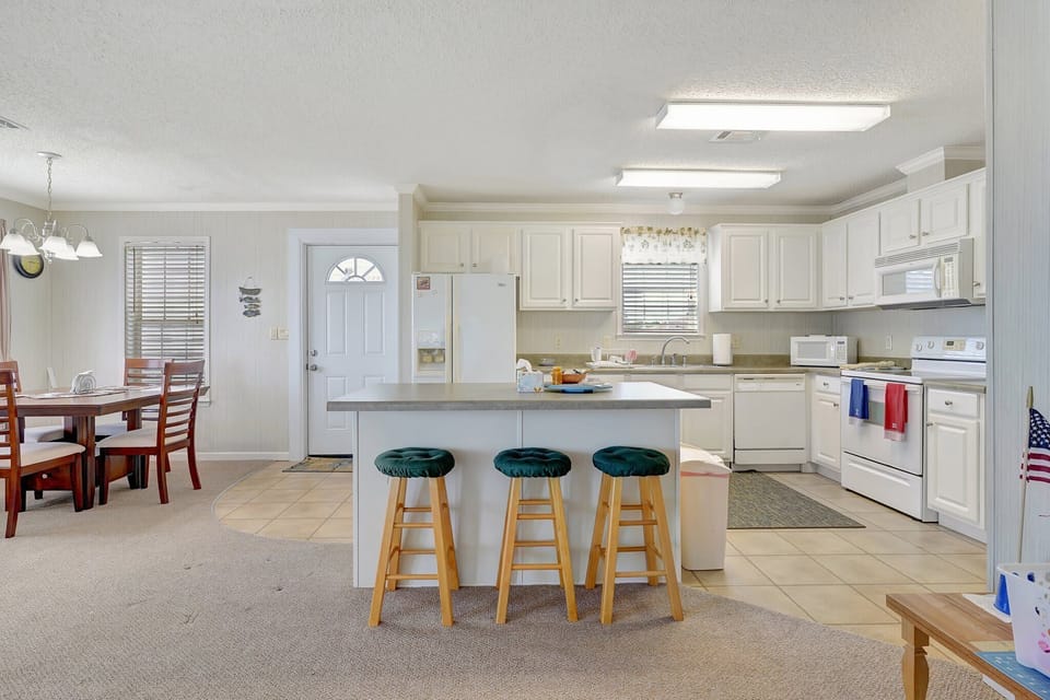 The kitchen opens up to the dining room, the front door is in the center of the photo