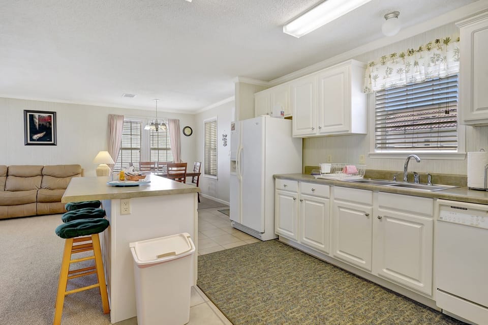 The kitchen is spacious and includes a large island with bar stools 