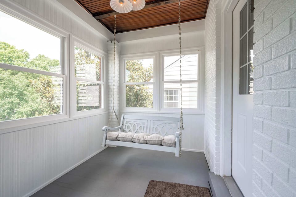 The sunroom porch swing is the perfect spot for relaxing with a book