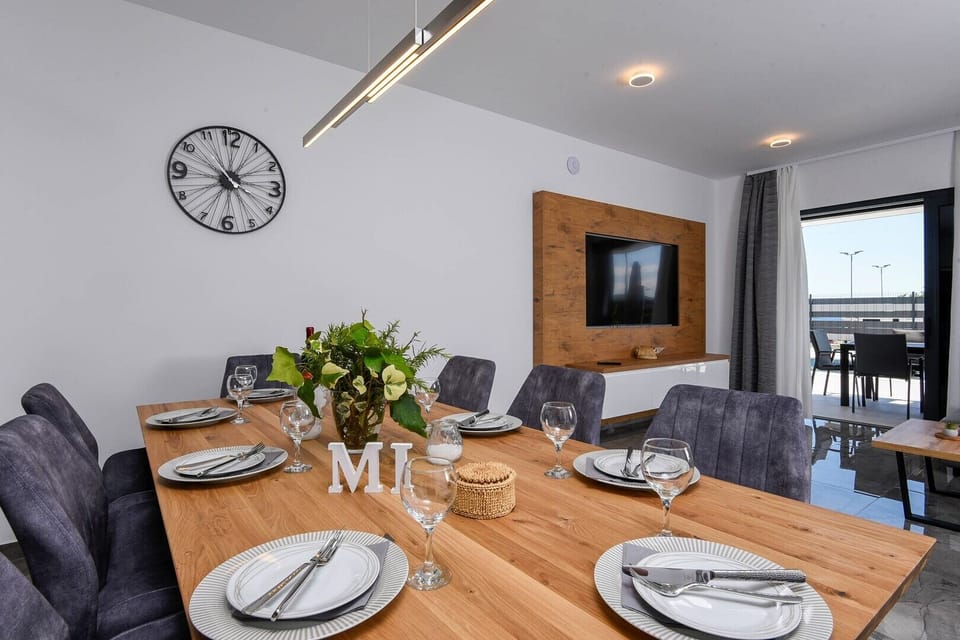 Dining and living area with TV in luxury sea view villa

