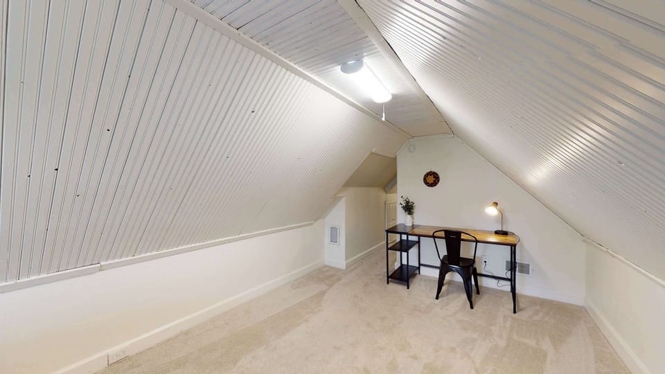 The 3rd-floor bedroom area includes a desk workspace & plush queen-sized bed