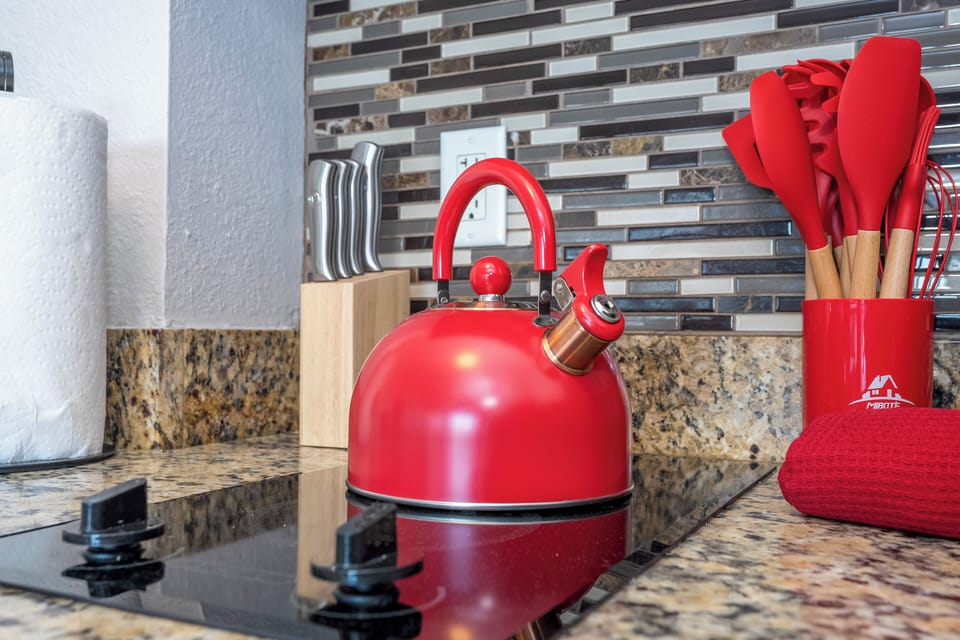 Cozinha completa com refrigerador, freezer, fogão, microondas, torradeira, cafeteira e chaleira de água quente, utensilios