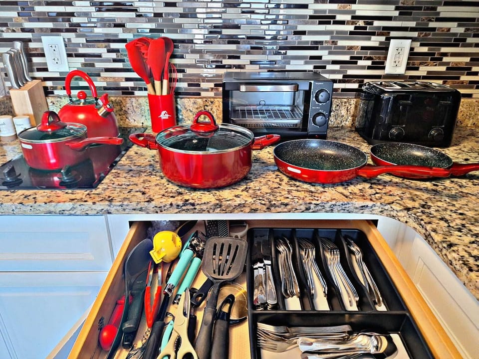 Cozinha completa com refrigerador, freezer, fogão, microondas, torradeira, cafeteira e chaleira de água quente, utensilios