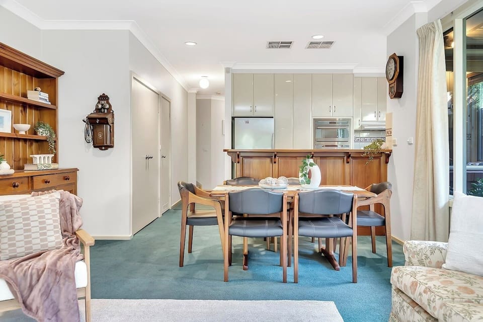 The dining area offers a warm and inviting space for family meals, with elegant wood accents and soft green hues.
