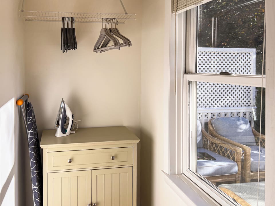 Bedroom: Walk-in closet with dresser, iron/iron board, and hangers