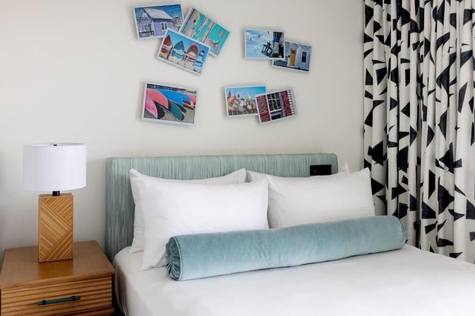 Sink into plush pillows beside bold curtains and coastal art.