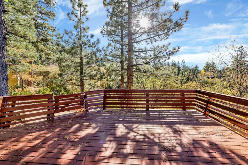 Private outdoor deck, surrounded by tall pines, perfect for relaxing under the trees after a day of adventure—enjoy peaceful forest views, fresh air, and a truly rejuvenating stay.