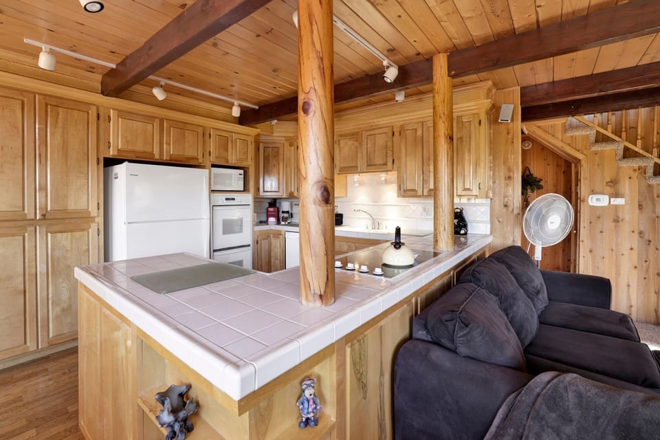 Fully equipped cabin kitchen with ample cabinetry, stove, fridge, microwave, and coffee maker—perfect for cooking meals, morning coffee, and feeling right at home on your stay.