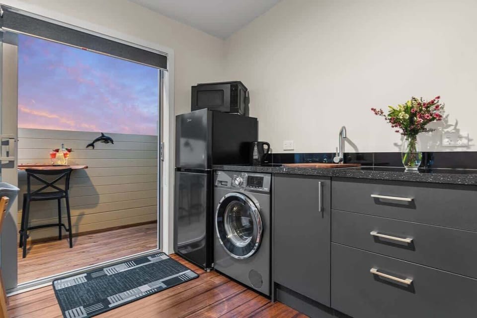 Kitchenette with fridge/freezer, washing machine, kettle, toaster, microwave oven & air fryer.