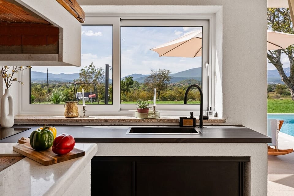 A kitchen top with an electric cooktop, and a sink 