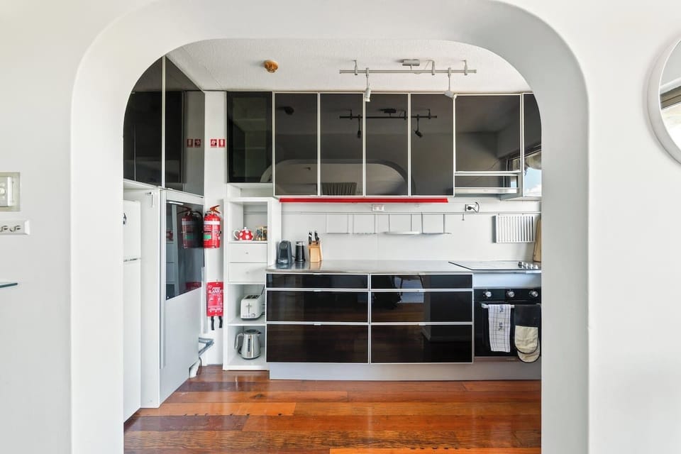 A fully equipped kitchen with a modern stainless steel countertop and sleek reflective cabinetry, ready for preparing meals while enjoying your stay.
