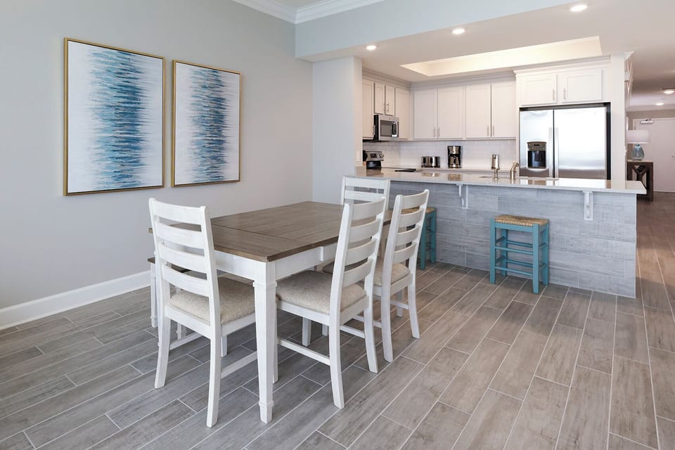 Sit at the wooden dining table beneath coastal art and plan your day along the gulf coast