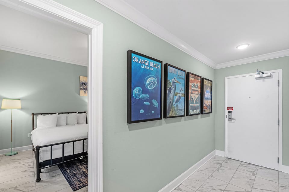 Pause in the foyer to spot vintage Orange Beach posters, peek into the bedroom inviting you ro explore