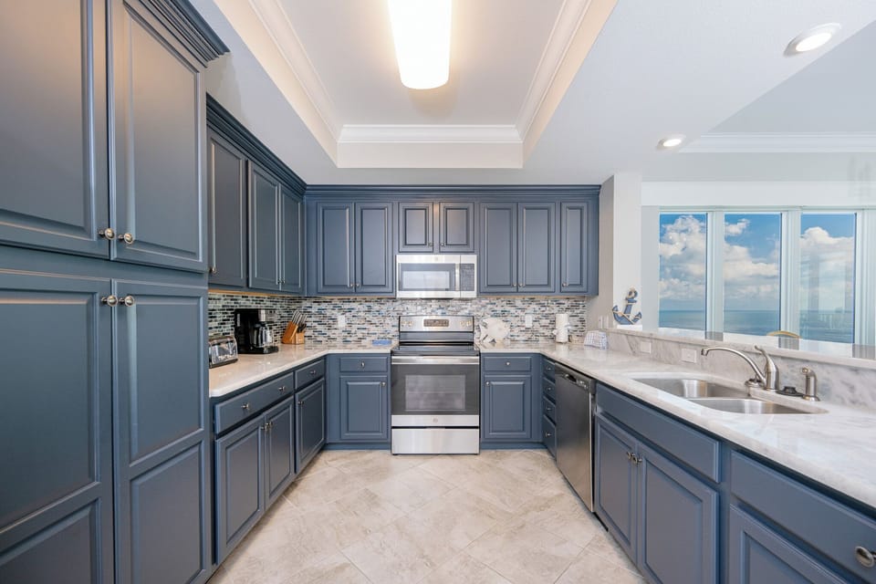 Prepare meals in this kitchen with elegant cabinetry, stainless appliances, and stylish backsplash