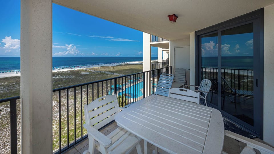 Balcony seating overlooks the beach, providing a perfect spot to relax and enjoy the stunning views of the gulf and pool area