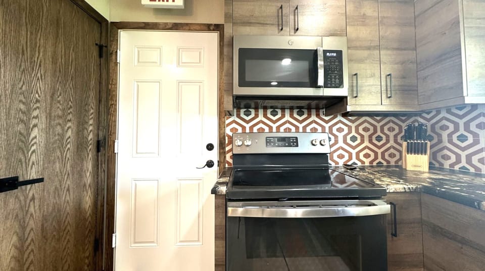 Our kitchen has a stylish island with three bar stools and modern appliances.