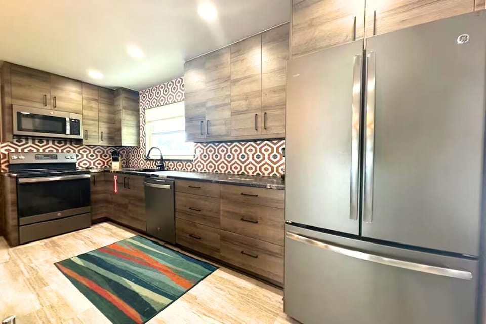 Our kitchen has a stylish island with three bar stools and modern appliances.