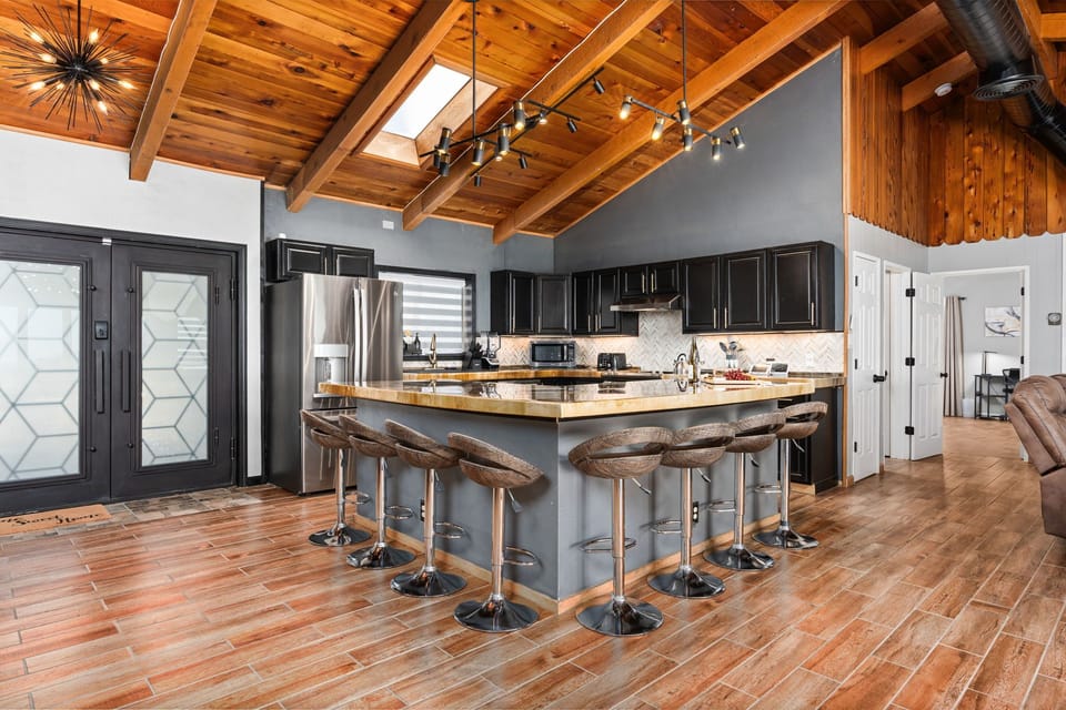 Main entry & kitchen: Bar seating for 8, custom counters, wood ceiling, skylight