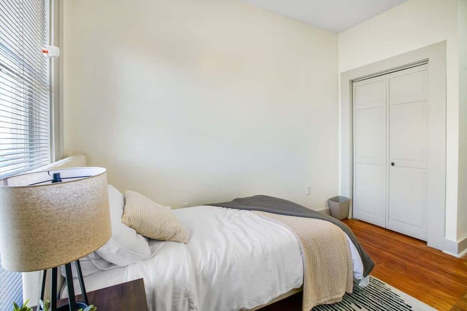 Cozy bedroom corner w/ bed, bedside lamp & closet storage