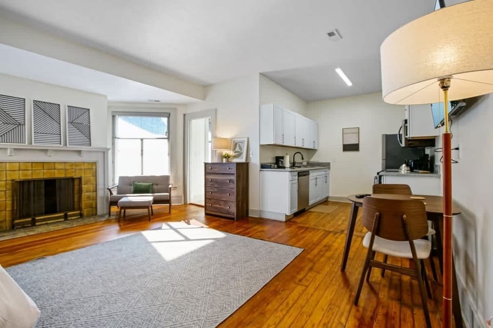 Sunlit open layout w/ fireplace seating, compact kitchen & dining nook for easy meals at home