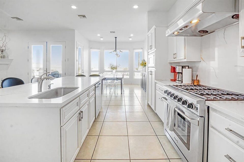 Kitchen - This modern kitchen features sleek all-white marble countertops and crisp white cabinets