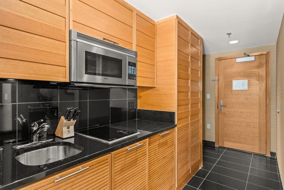 The kitchenette may be small, but it packs a punch — equipped with a stove, fridge, microwave, and all the essentials for cooking small meals.