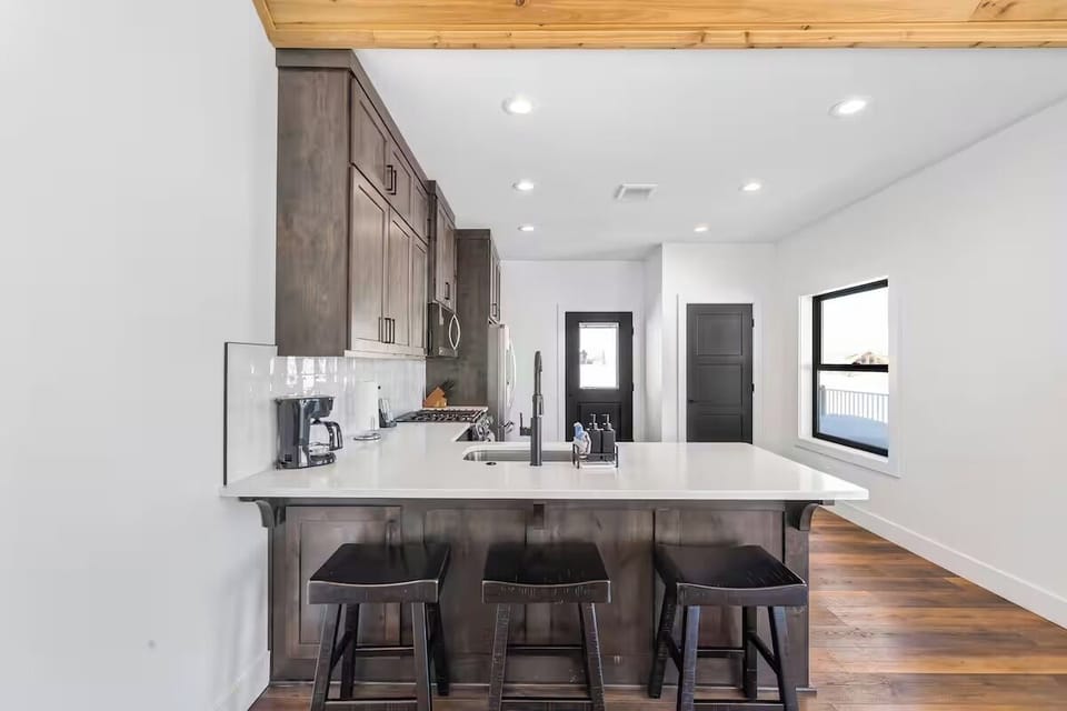 Kitchen with modern appliances, spacious counters, and bar seating.