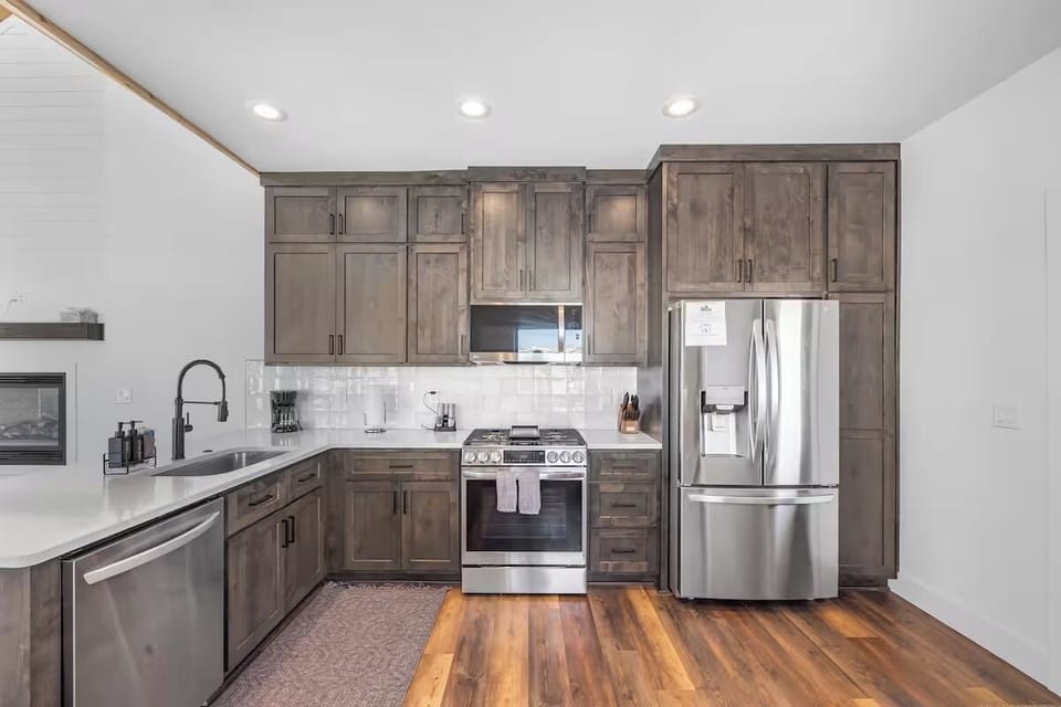 Kitchen with modern appliances, spacious counters, and bar seating.