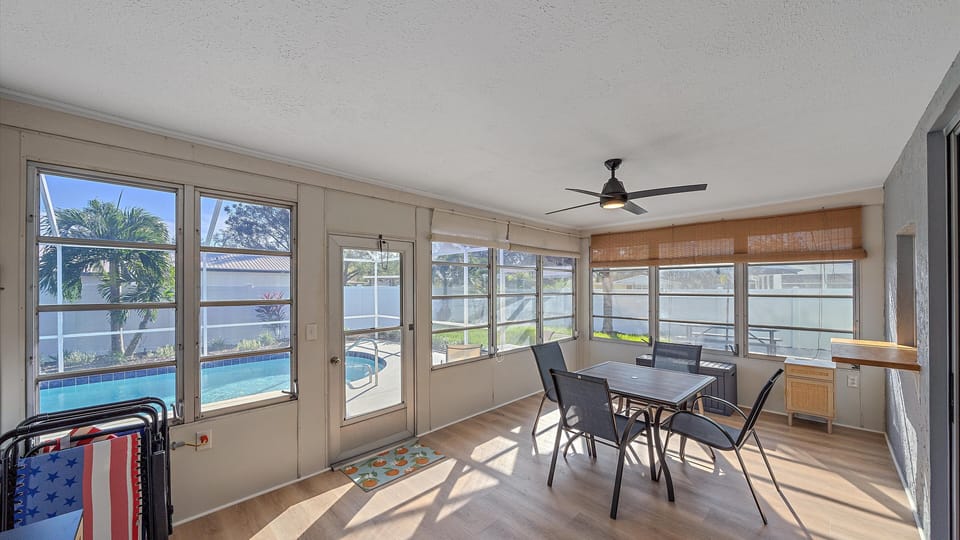 Enjoy year-round comfort in the enclosed Florida sunroom, offering a lovely dining space with expansive, bright views of the private, screened pool and backyard.