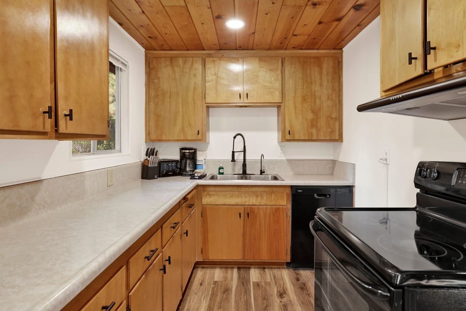 Fully equipped cabin kitchen with ample cabinetry, stove, fridge, and a coffee maker—perfect for cooking meals, morning coffee, and feeling right at home on your stay.