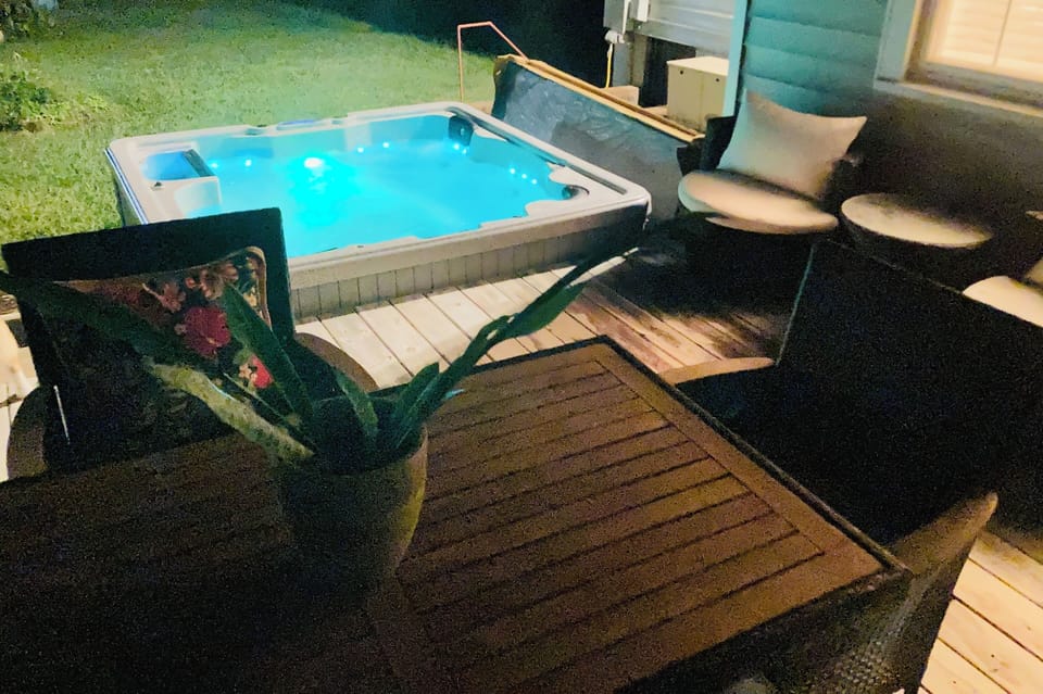 Secluded hot tub in fully fenced in back yard of the lighted back patio @ night