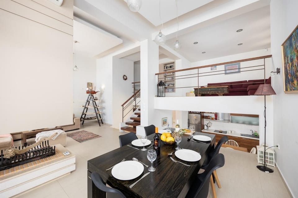 Open-plan living room with sofas, dining area, kitchen, ornamental fireplace, A/C, WiFi internet, satellite TV, and sea views