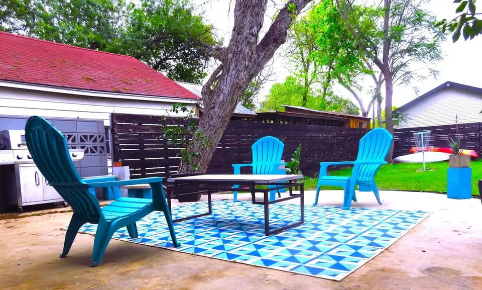 Large backyard with grill, cornhole, golf practice area, and frisbee golf. 