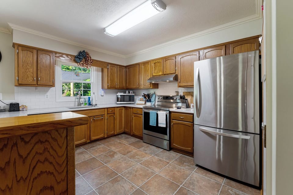 Kitchen with fridge, stove with oven and microwave to store and make your food.