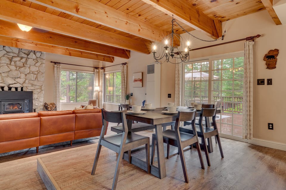 - Dining table with seating for six in bright open-concept area  
- Rustic chandelier and wood ceiling beams add mountain charm  
- Glass doors open to deck for seamless indoor-outdoor living