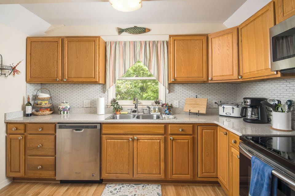 Bright kitchen with wood cabinets and tile backsplash.