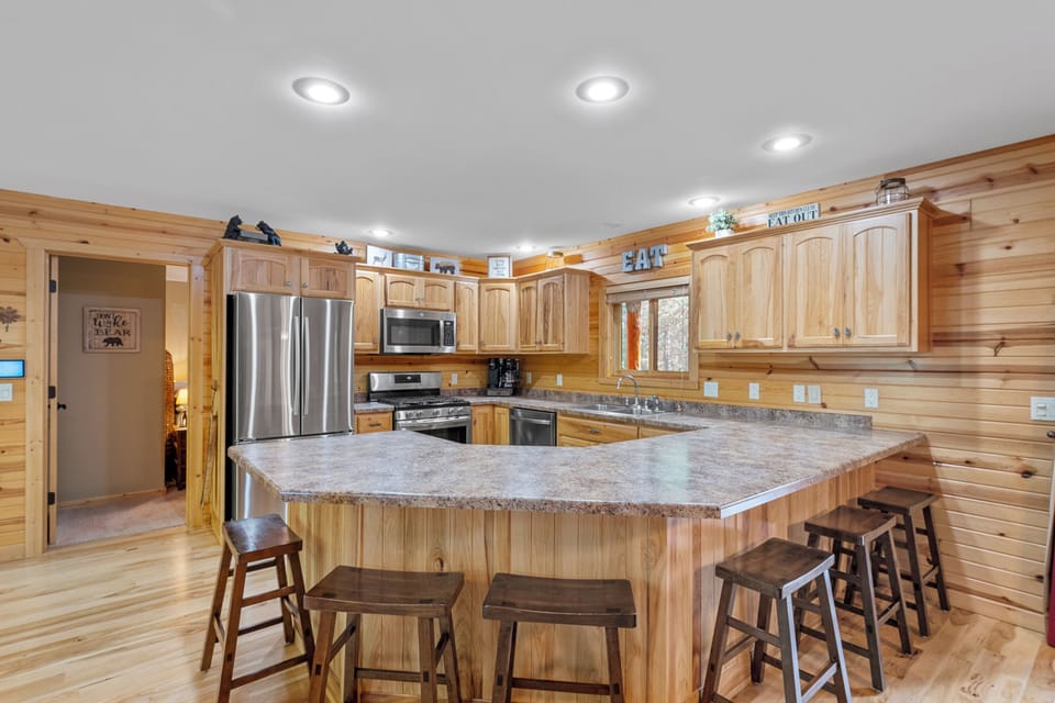 The kitchen is fully equipped and has ample seating right off of the dining area for all to enjoy a family meal together.