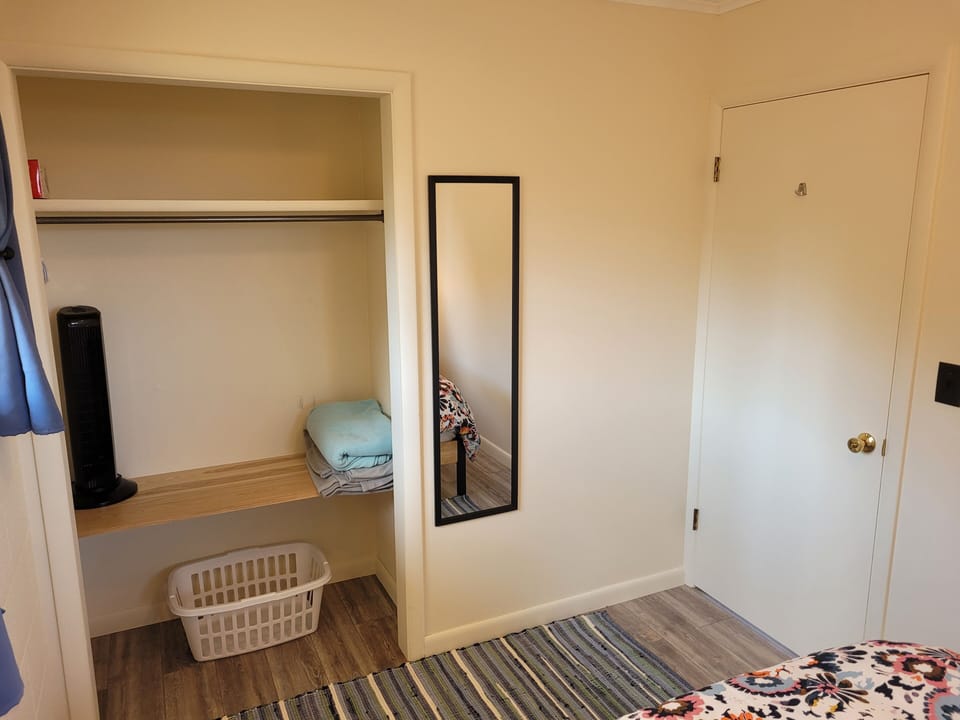 BEDROOM #1:  Features a queen-size bed, nightstands, lamps, mirror, and closet.