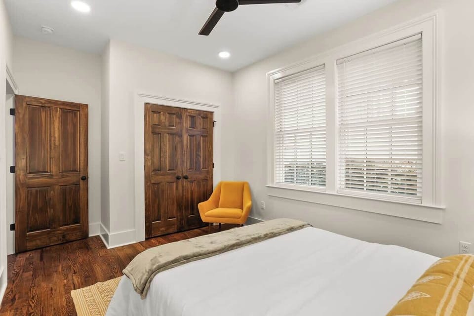 Bedroom with queen bed, large windows, and spacious closet—comfortable and practical for longer stays.