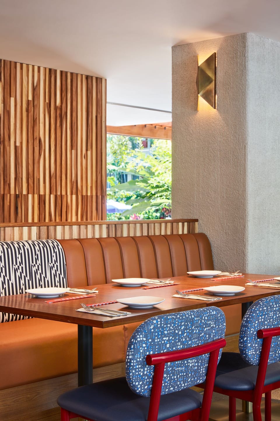 This inviting dining nook, with a blend of modern design and bold colors, offers the perfect spot for a relaxed meal in comfort and style.