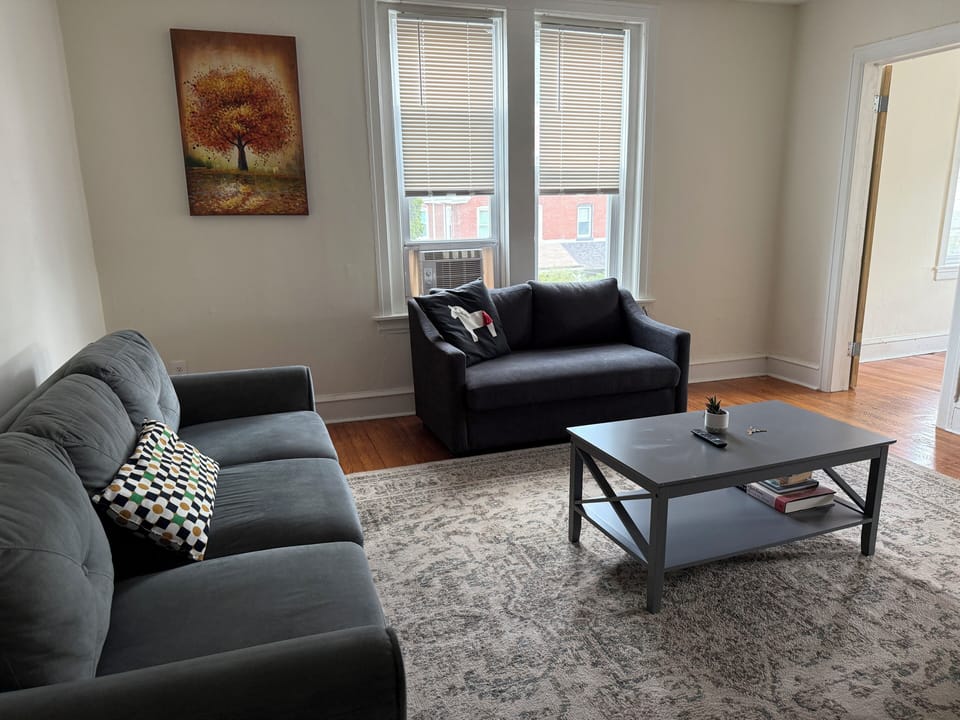 The living room is furnished with all the essentials, including a cozy sofa, coffee table, and TV, offering immediate comfort and a welcoming atmosphere from the moment you move in.
