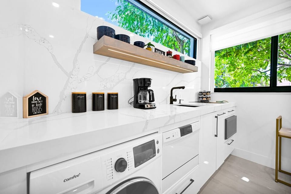 "Stylish kitchen with sleek design, natural light, and greenery views."