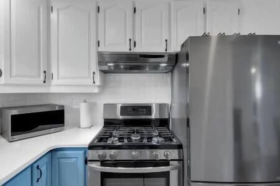 Kitchen has a microwave, stove and fridge